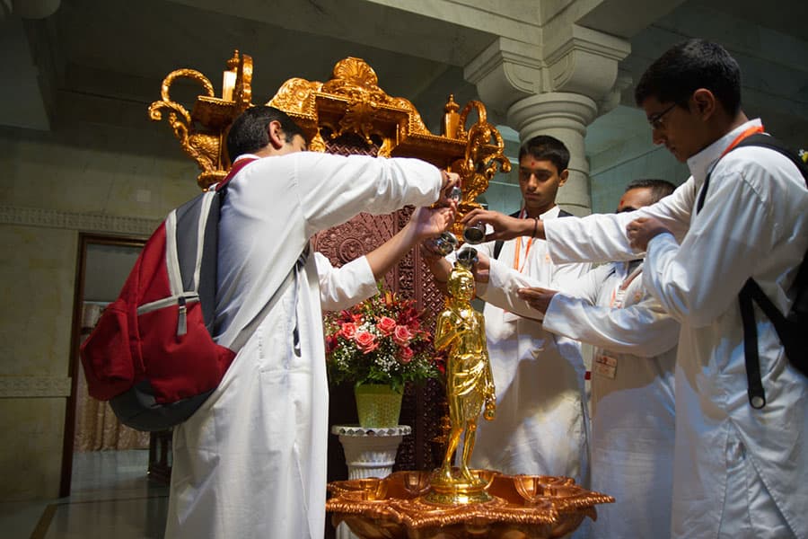 Youths performing abhishek of Shri Nilkanth Varni Maharaj